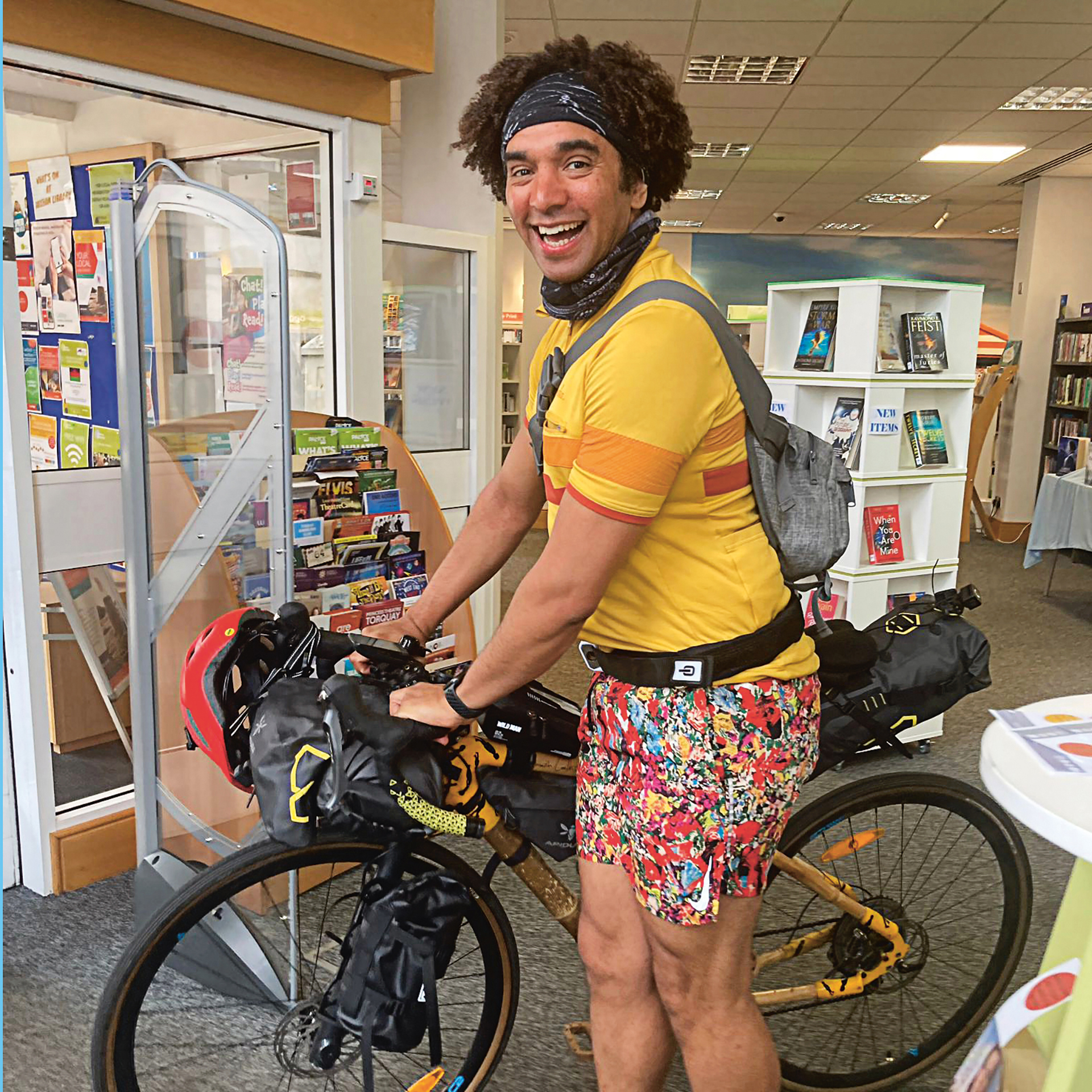 Joseph Coelho with his bicycle in a library