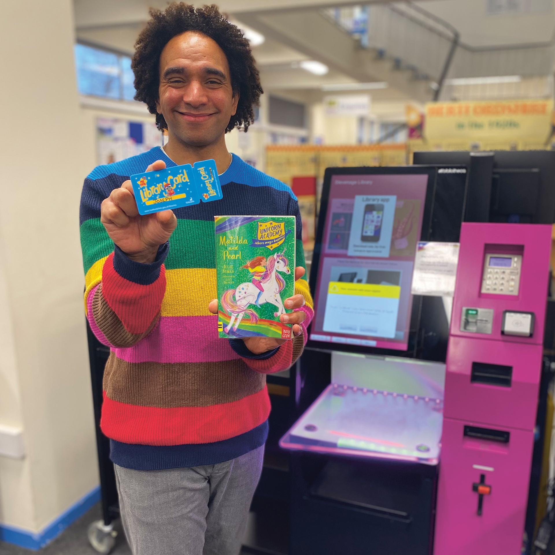 Man holds up library card and a book