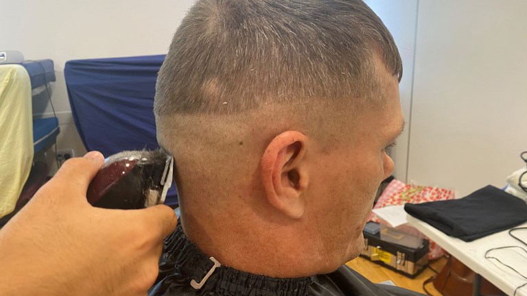 A man is getting his hair cut with clippers