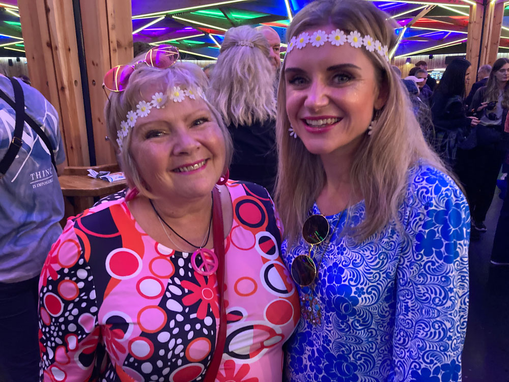 a mother and daughter wearing bright patterns with daisies in their hair