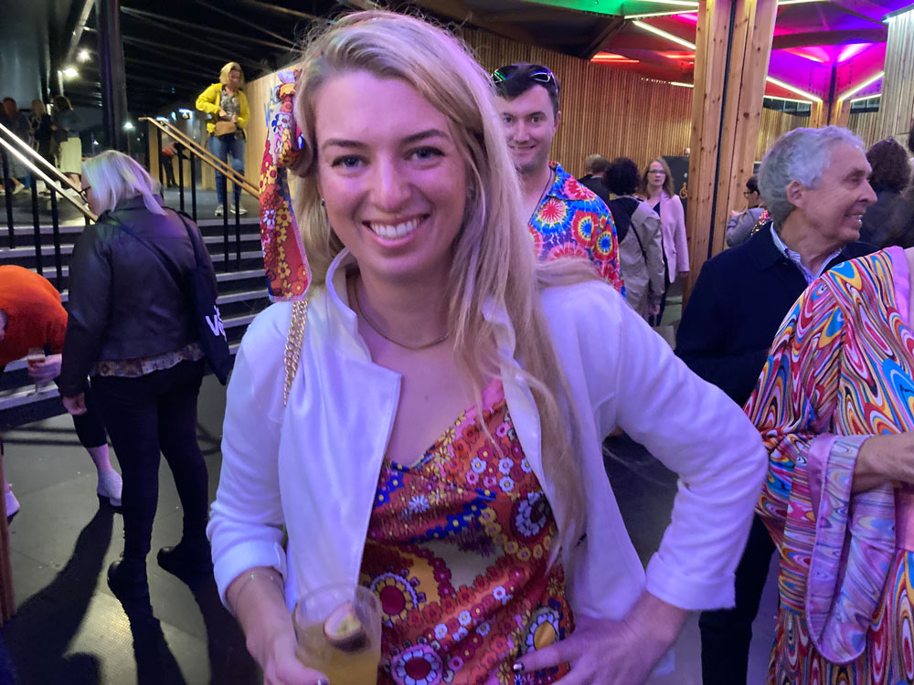 A smiling blonde lady in a 70s outfit at ABBA Voyage