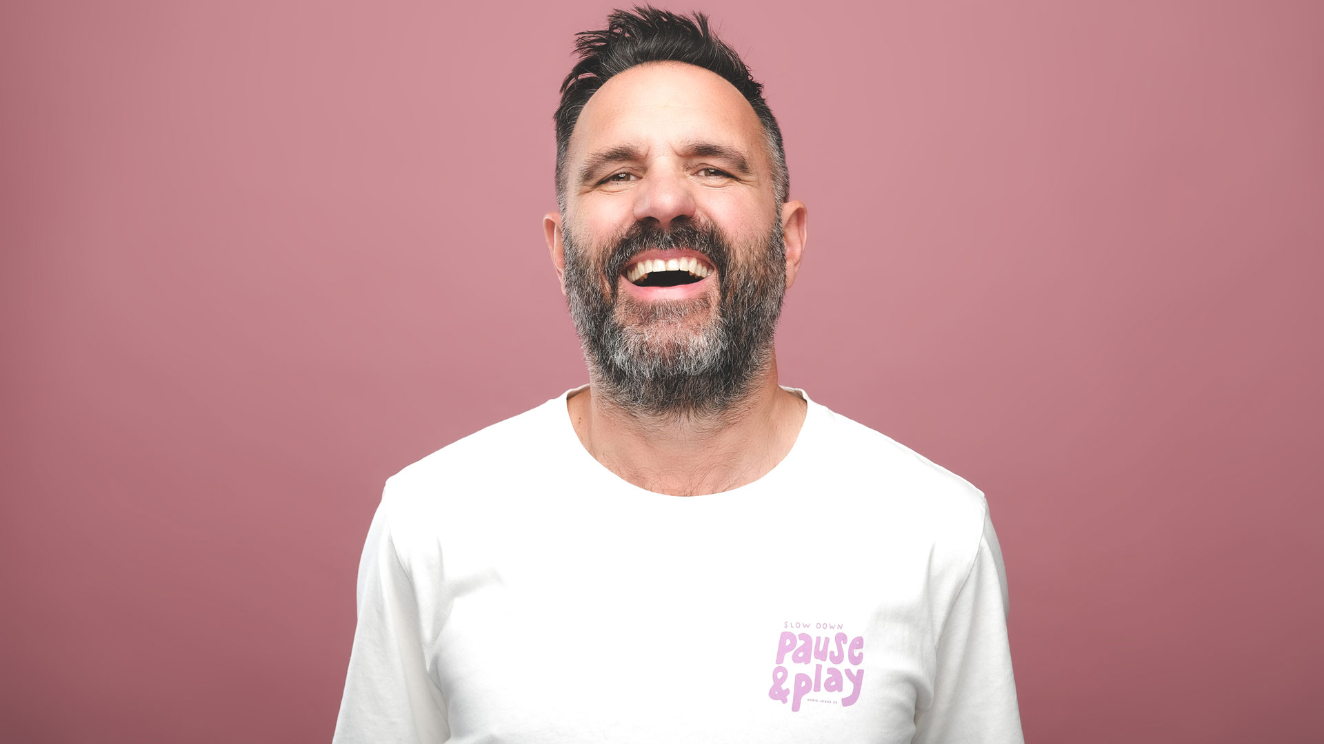 Shaun Keaveny in a white t-shirt, smiling