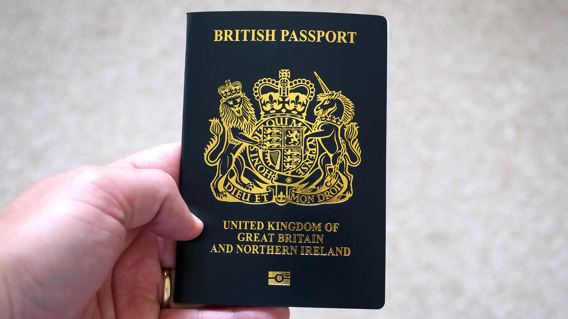 A hand holding a British passport