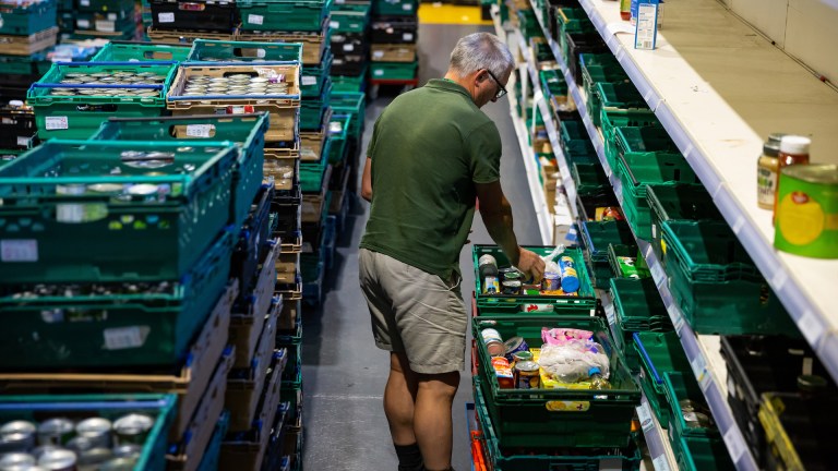 a man sorts food donations into crates at a food bank