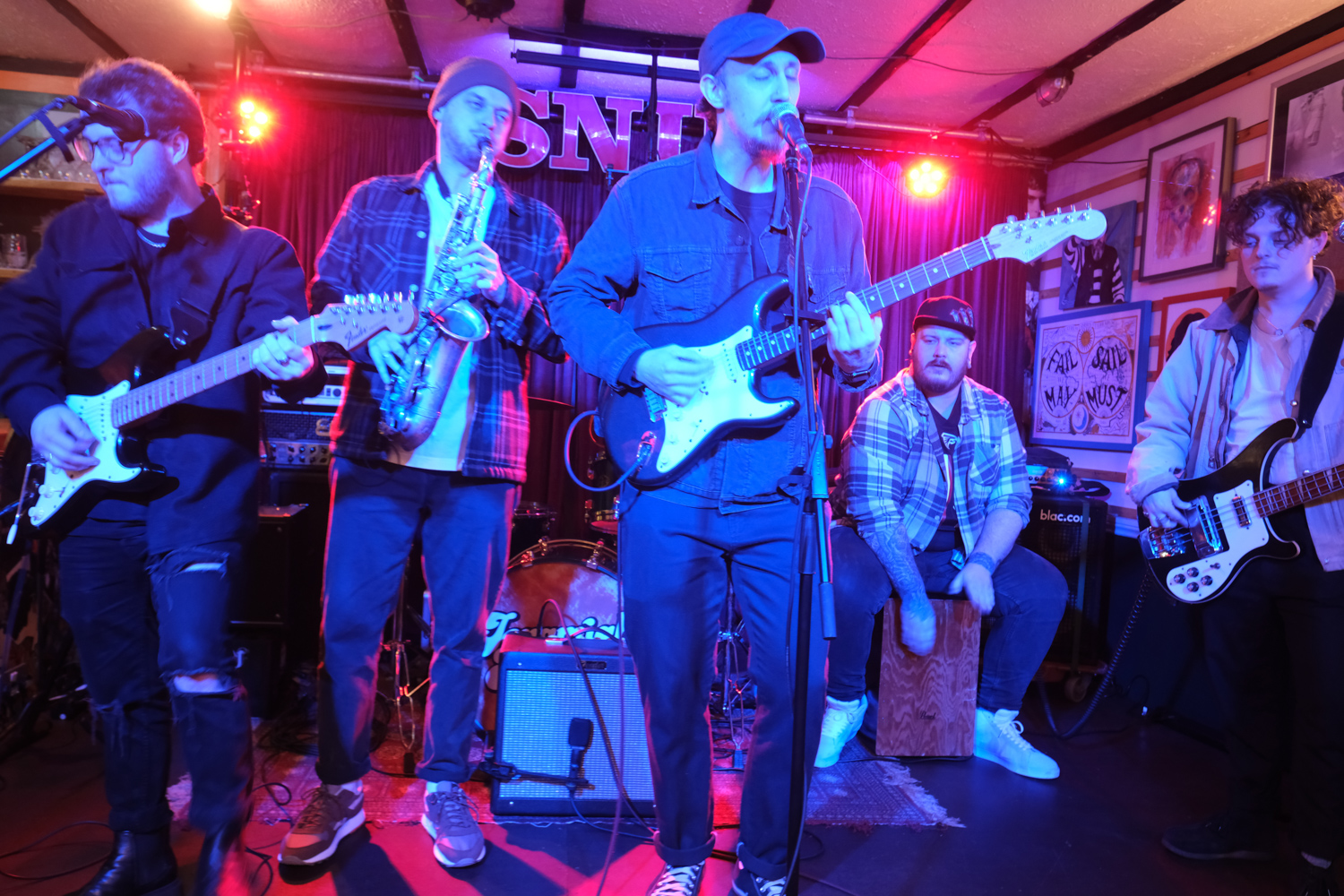 a band playing guitars and saxophone