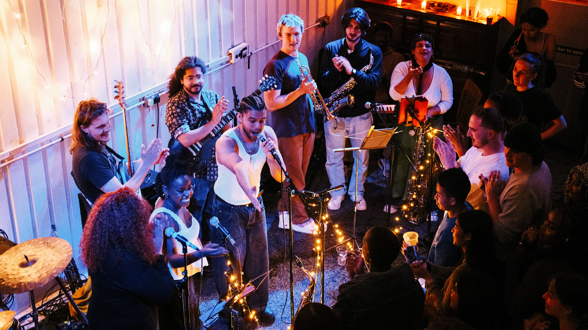 A crowd applauds a band on stage at Matchstick Piehouse