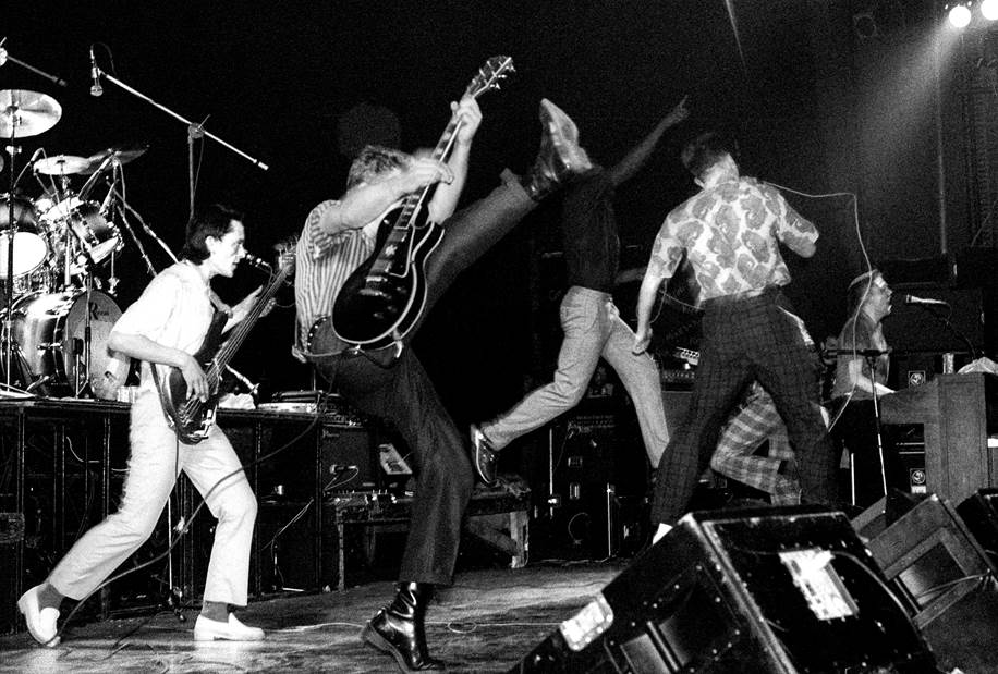 Members of The Specials in mid air as they perform