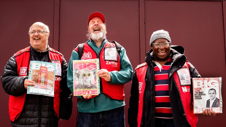 Three big issue vendors smiling holding magazines