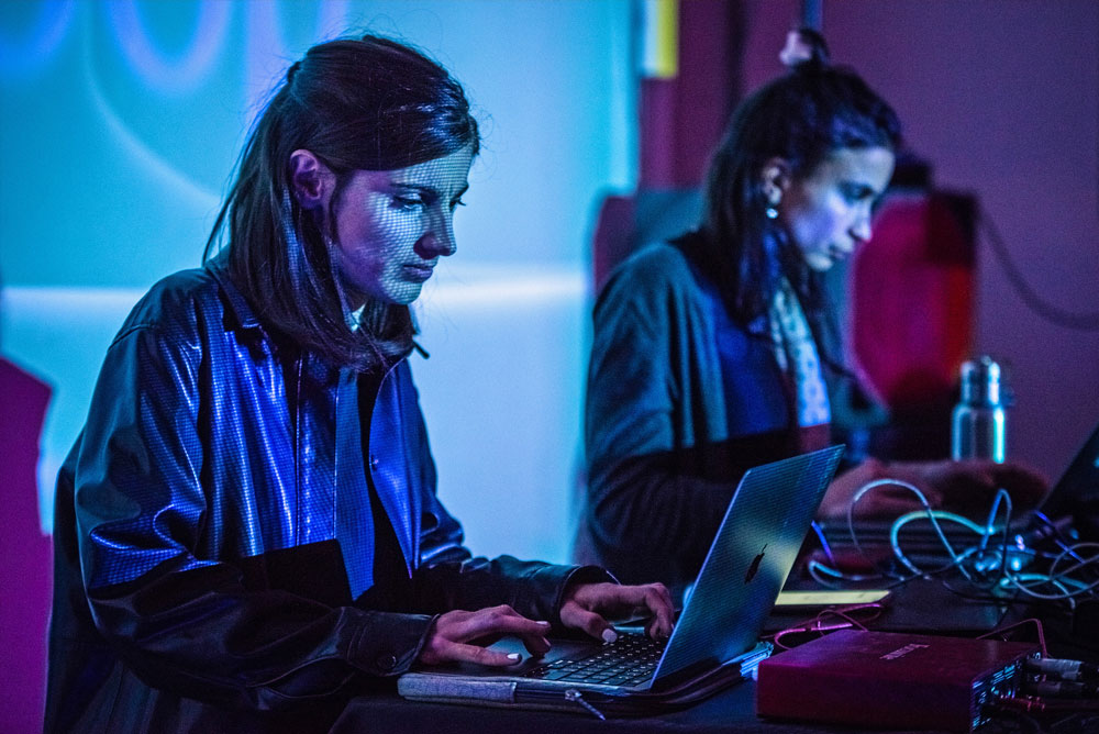 Two women playing music on computers