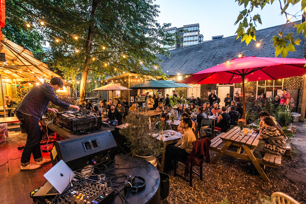 a crowd sit outside Iklectik and watch experimental music