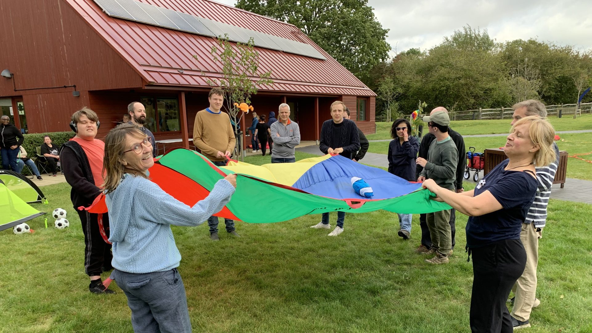 Parents and children take part in a sensory parachute exercise at Linden Farm