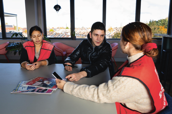 3 people sitting at table receiving training