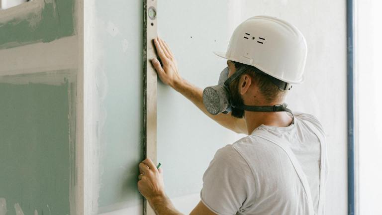 a worker replastering a wall