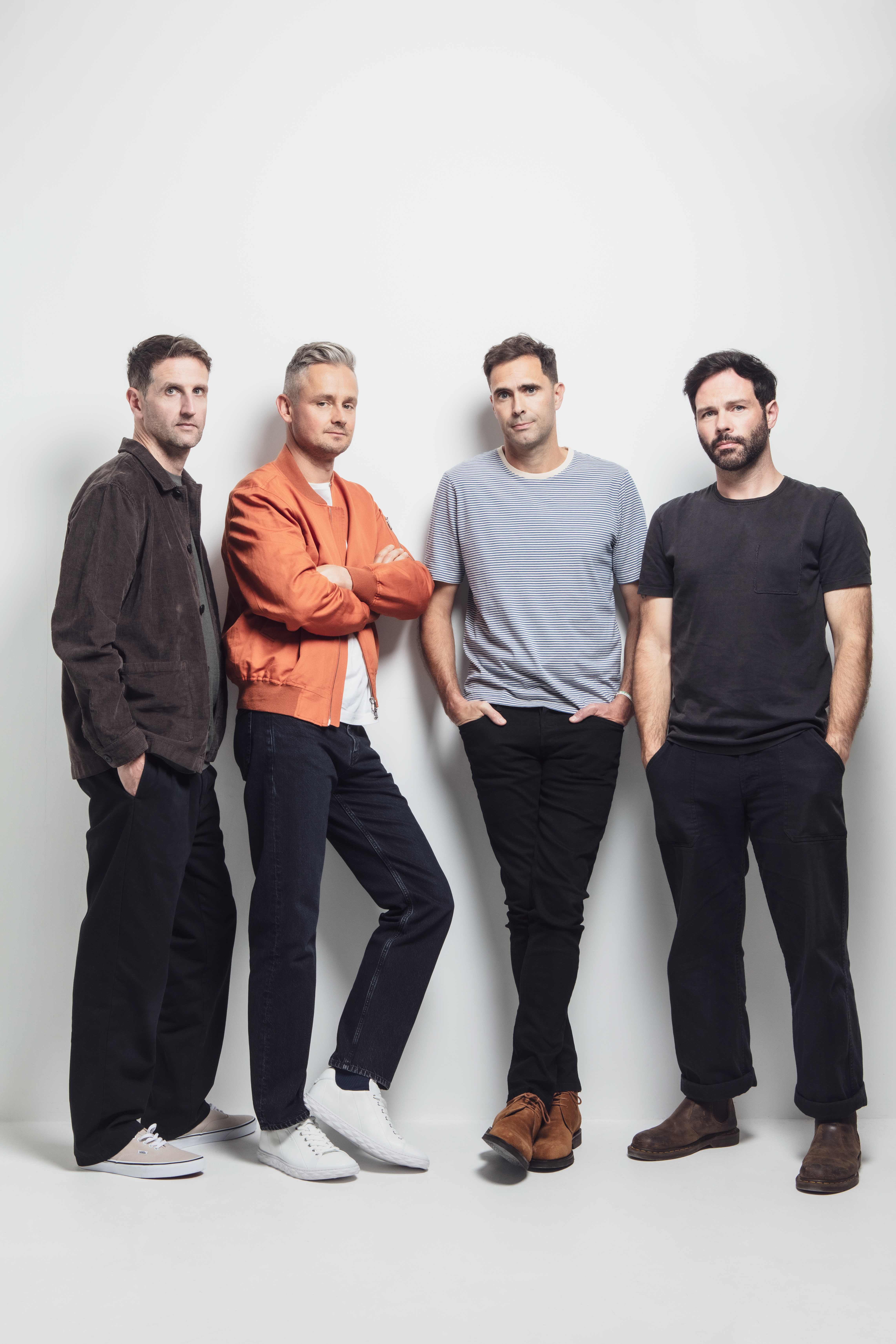 Pop-rock band Keane stood against a white wall