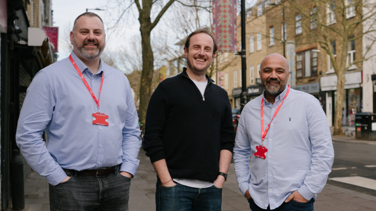 Head of Big Issue Recruit Operations Stuart Greenway, Big Issue Recruit candidate Kane and Big Issue Recruit job coach Shak Dean stand outside Big Issue Group's head office in Finsbury Park, London.