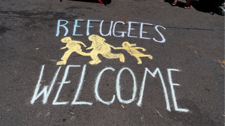A refugees welcome sign painted on the ground