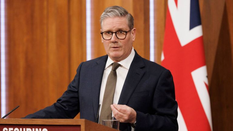 Prime Minister Keir Starmer stands in front of a Union Jack flag