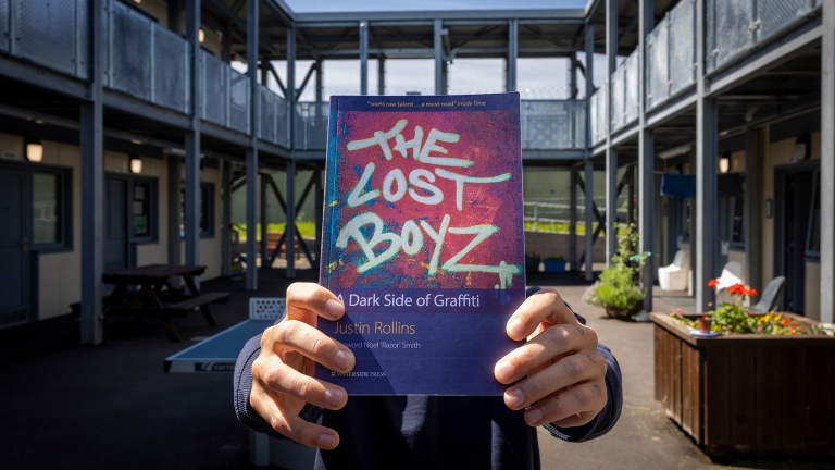 An inmate at HMP Erlestoke holding the book The Lost Boyz at Penned Up 2025