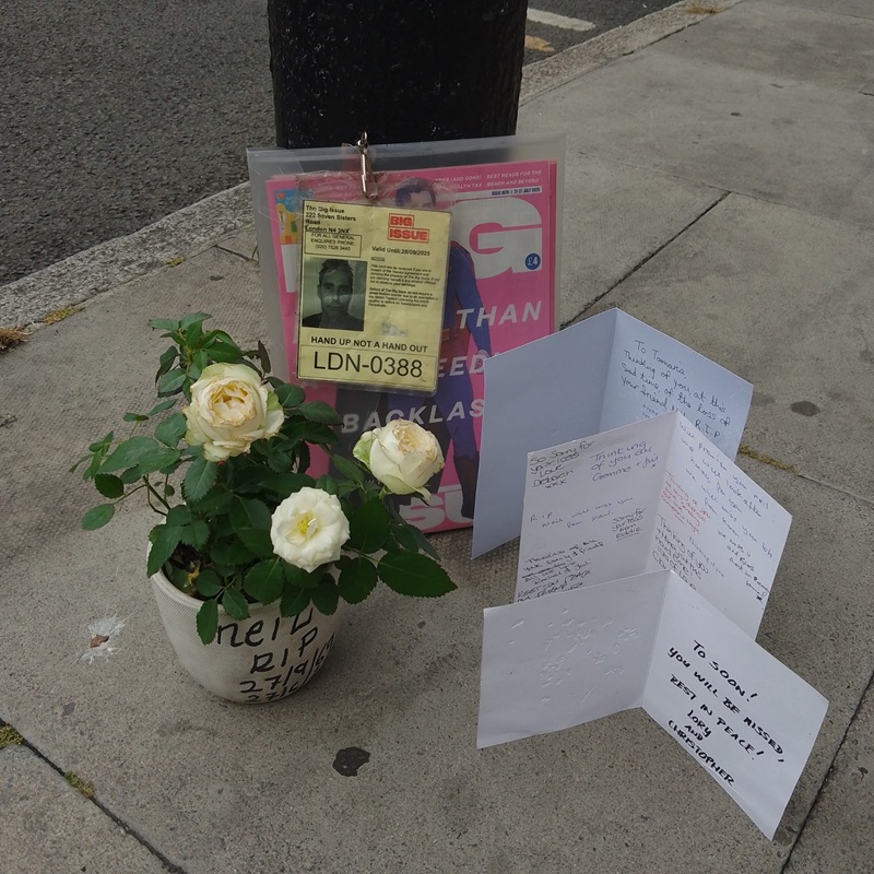a photo of the tributes left on Big Issue vendor Neil Smith's pitch