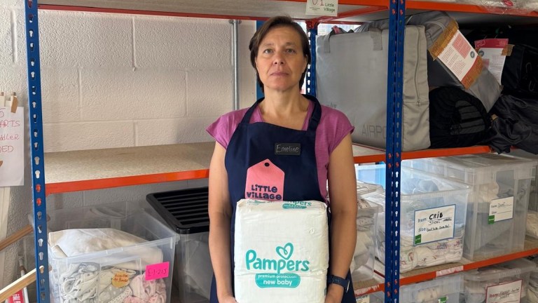 Emeline, volunteer at Little Village's Brent baby bank holding a pack of pampers