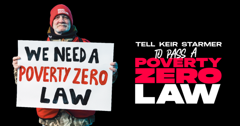 big issue vendor holding up a 'we need a poverty zero law' sign