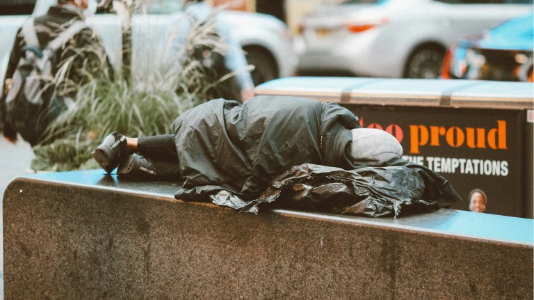 a homeless person lying on a bench