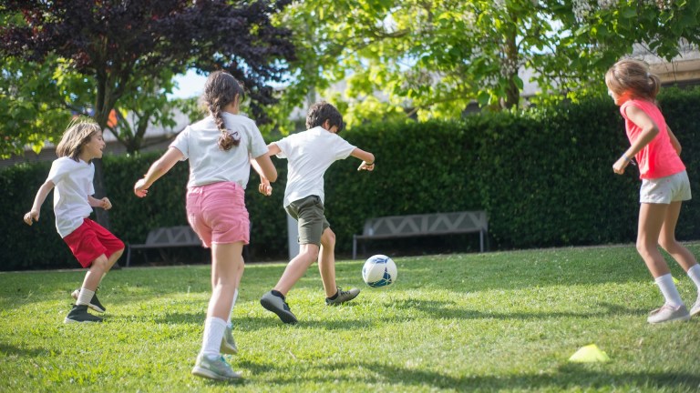 A group of children playing football together.
