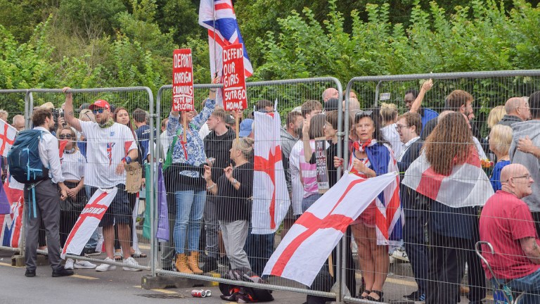 anti-immigration protesters behind a fence