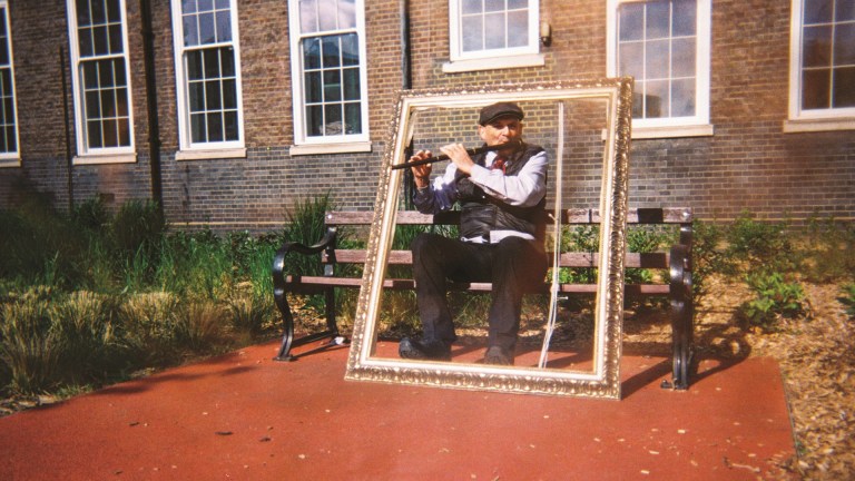 a man playing flute sat in a frame