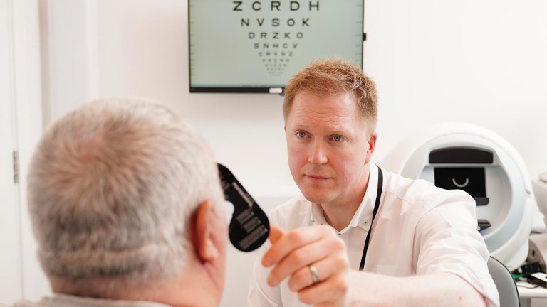 showing the optometrist conducting a professional eye test with proper equipment