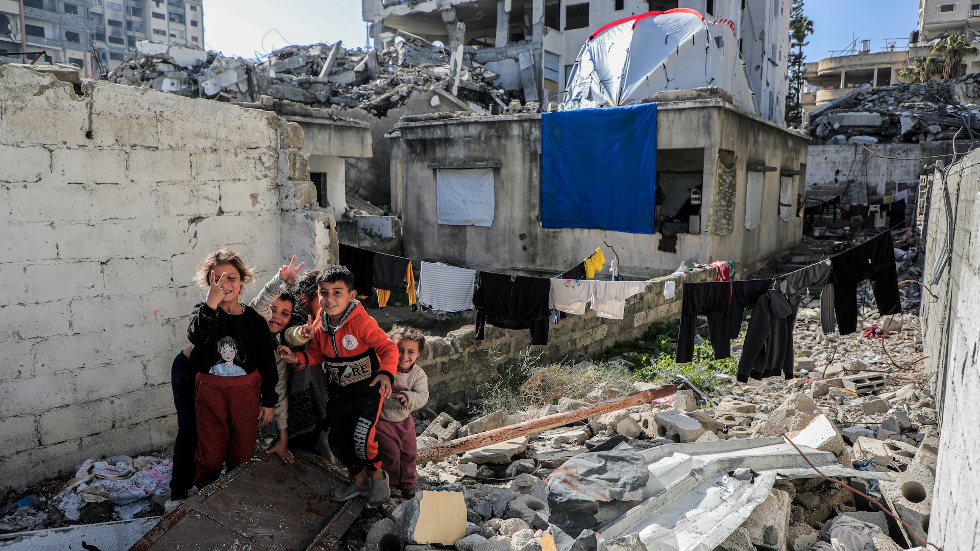 A group of children standing on rubble in Gaza.
