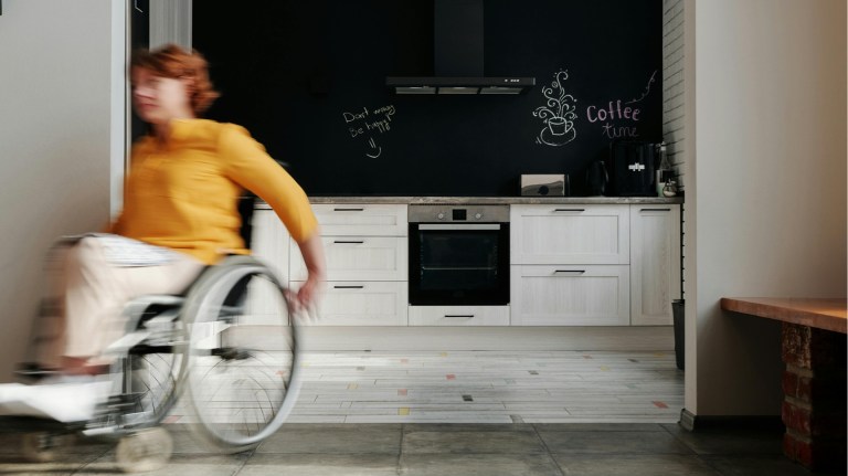a person in a wheelchair at a home with a chalkboard