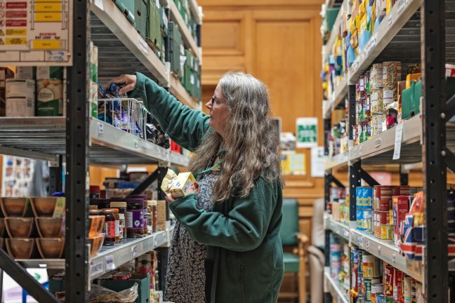A Trussell food bank worker sorting food parcels.