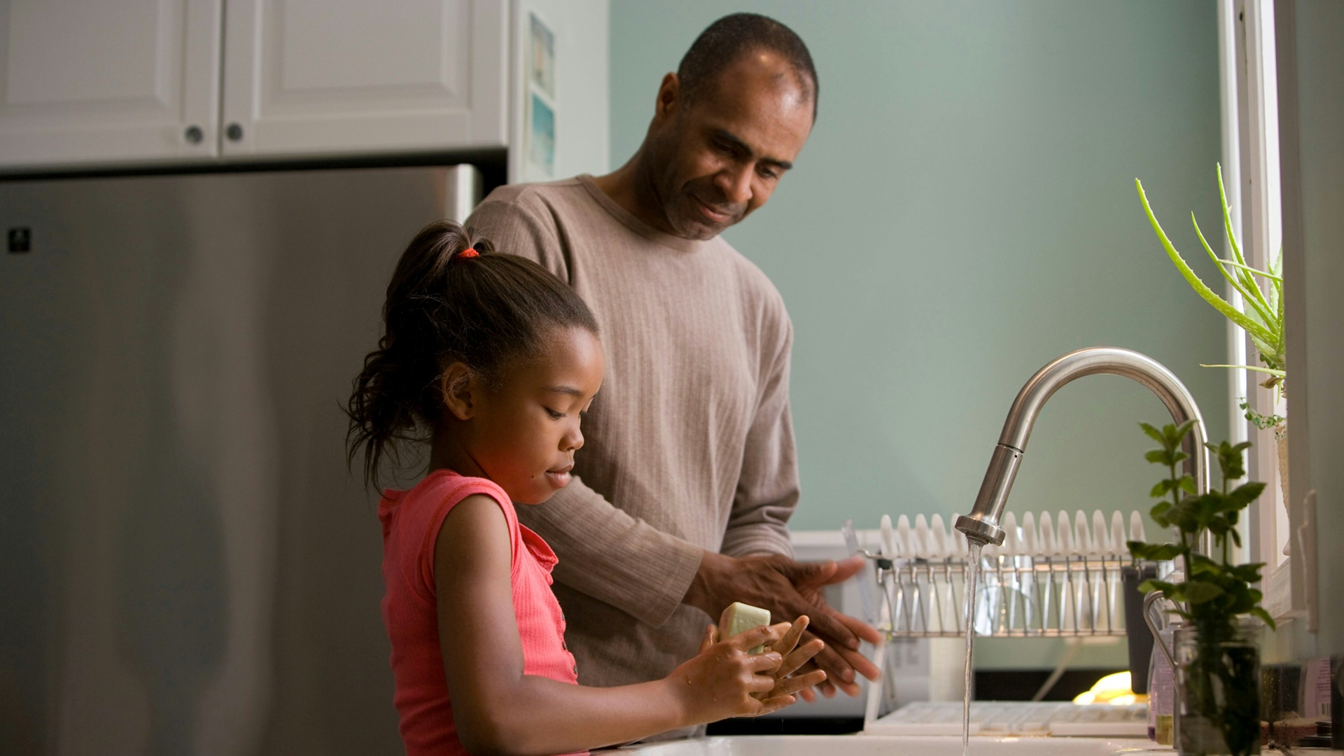 a father and daughter washing hands