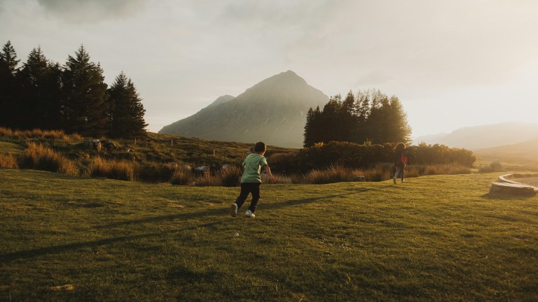 Children running through the Scottish highlands.