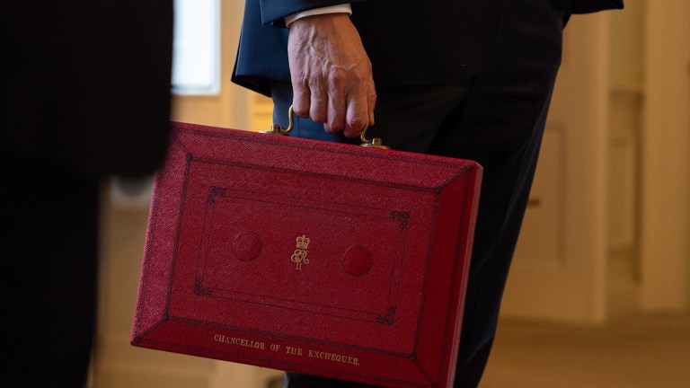 A chancellor of the exchequer holding the briefcase containing the government's budget.