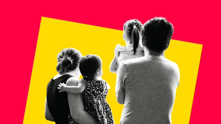 Image of two parents holding two small children, facing away from the camera