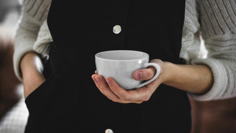 a woman holding a cup of tea