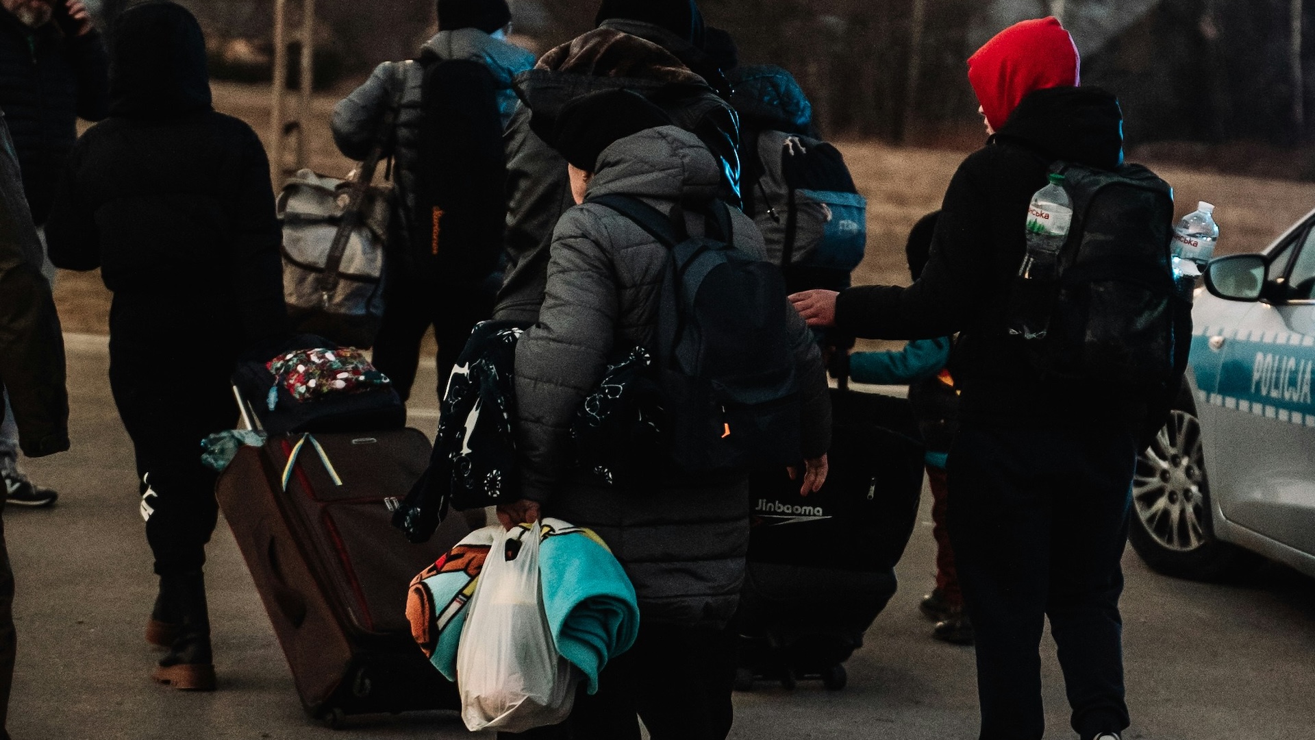 A group of Ukrainian refugees walking with their belongings.