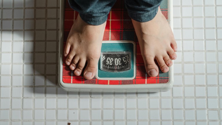 A person stepping onto weighing scales