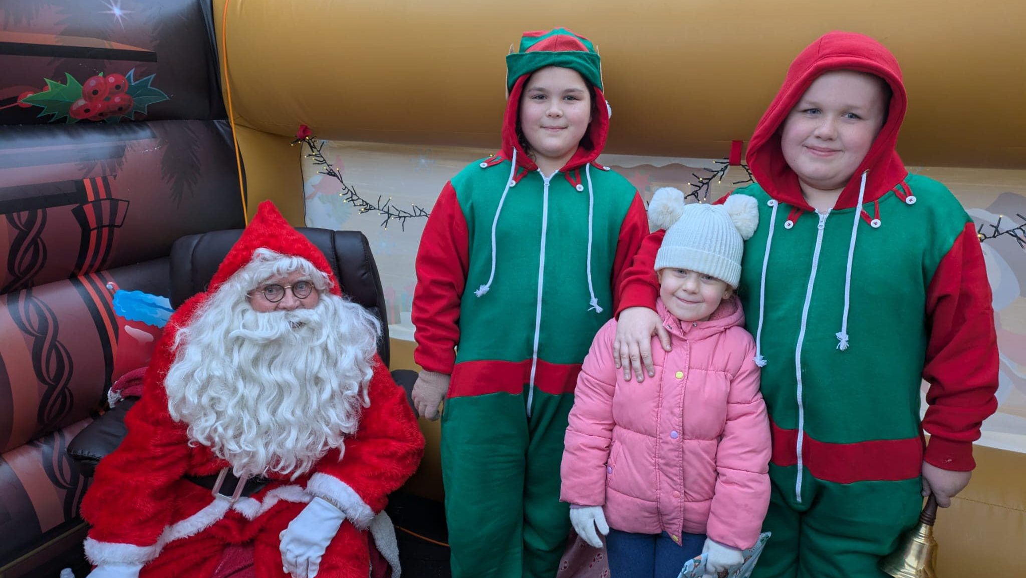 A santa with children dressed in Christmas costumes