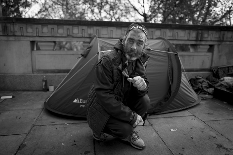 A man posing in front of a tent