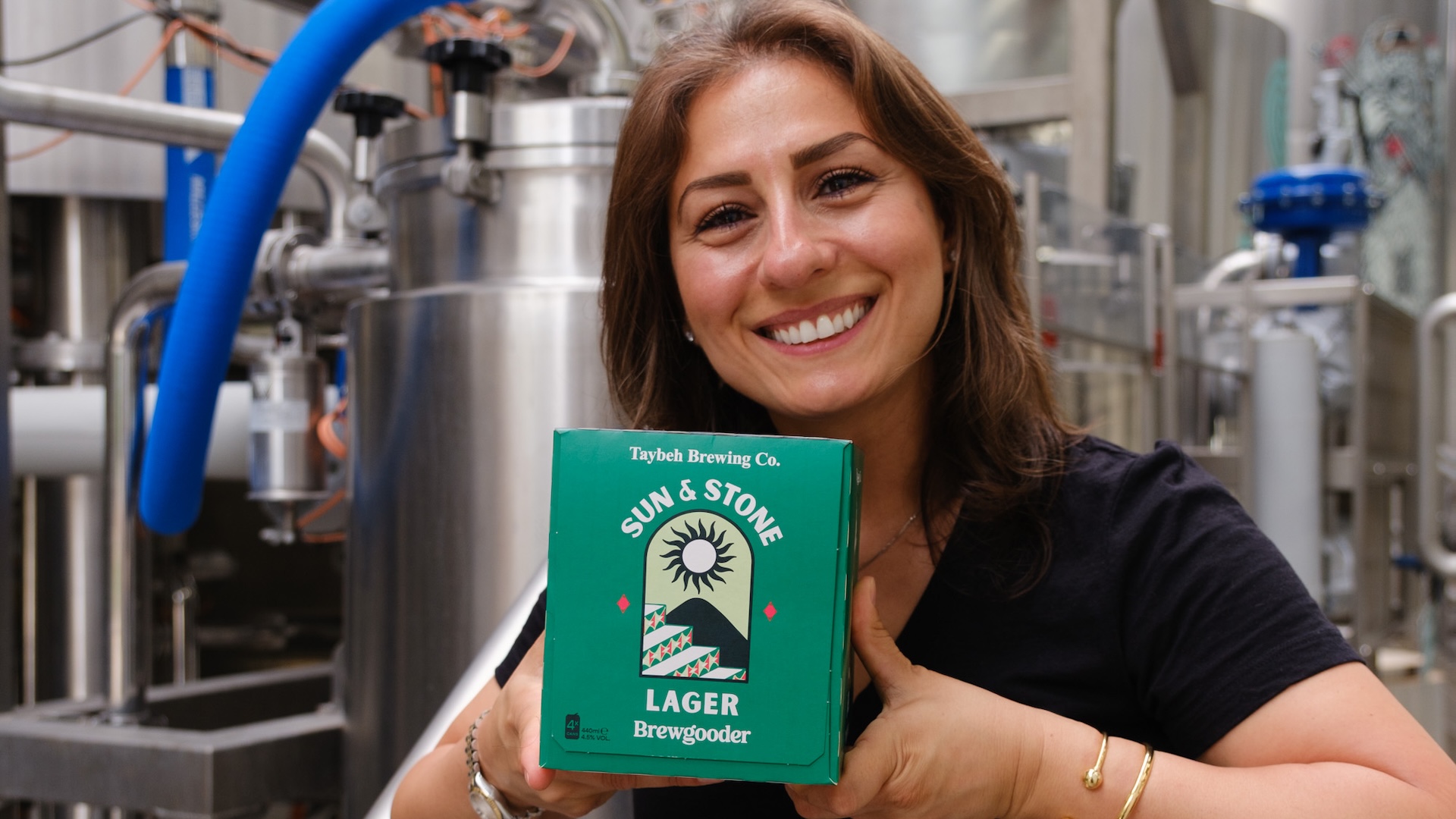 Madees Khoury holding Sun & Stone, the beer which Taybeh Brewery made with Brewgooder.