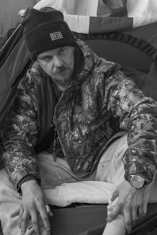 A portrait of a man in a knitted hat and a camouflage jacket