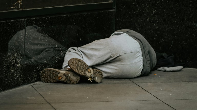 a person experiencing homelessness lying down on the street