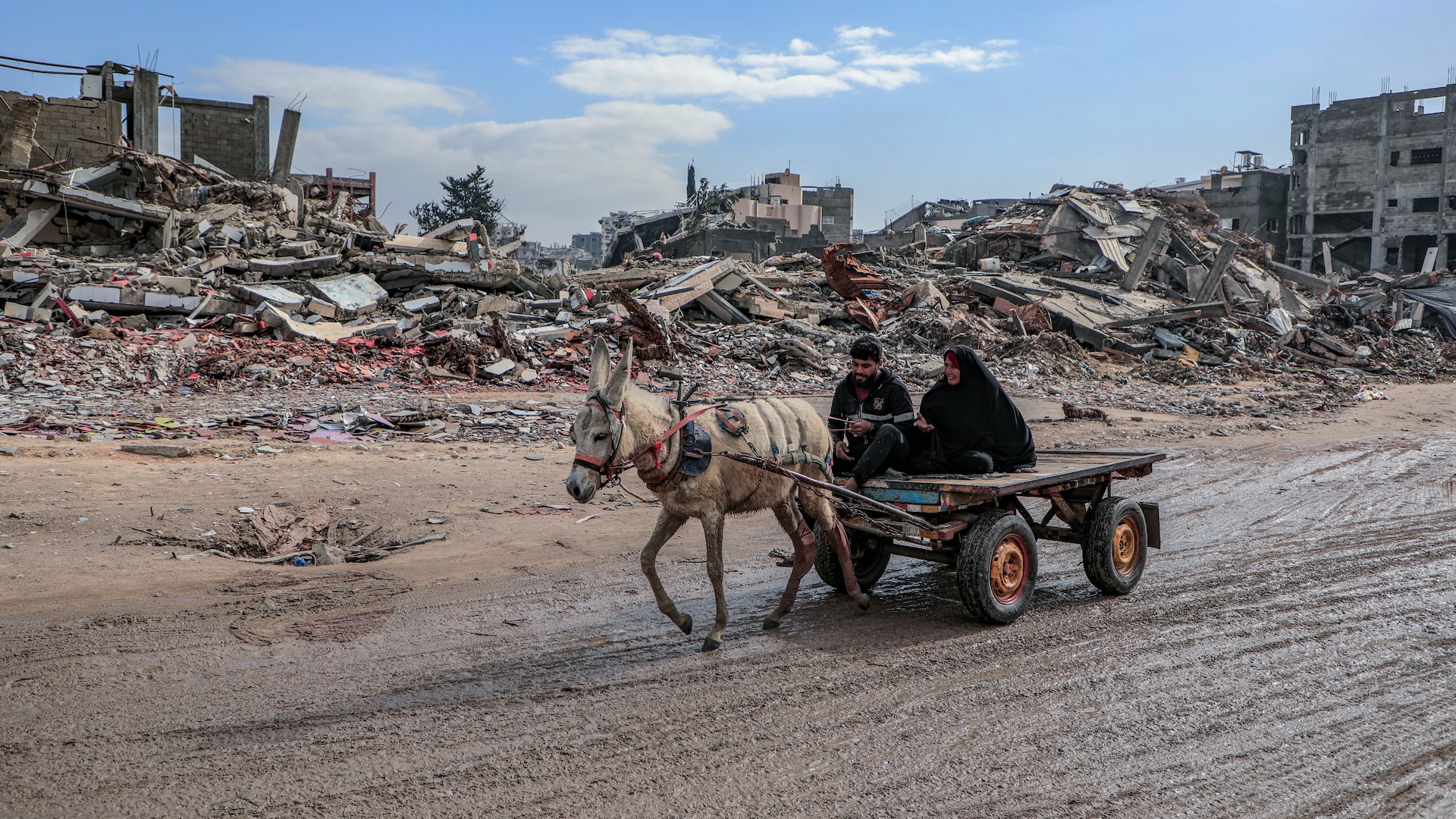 Destruction in Gaza. Donkey pulling cart with people on it.