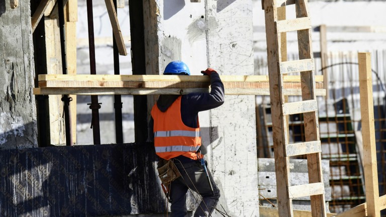 a builder carrying wooden planks