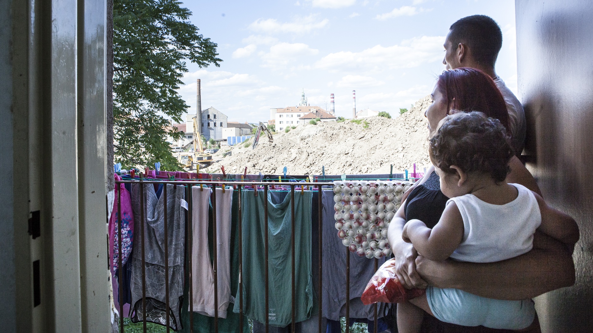A family supported by Platform for Social Housing in the Czech Republic looking out their balcony