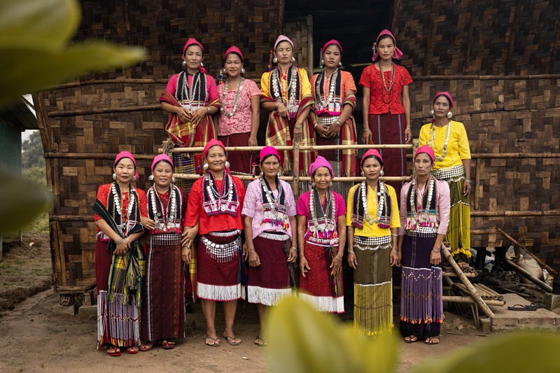 Women in front of NGO Housing NOW homes in Myanmar
