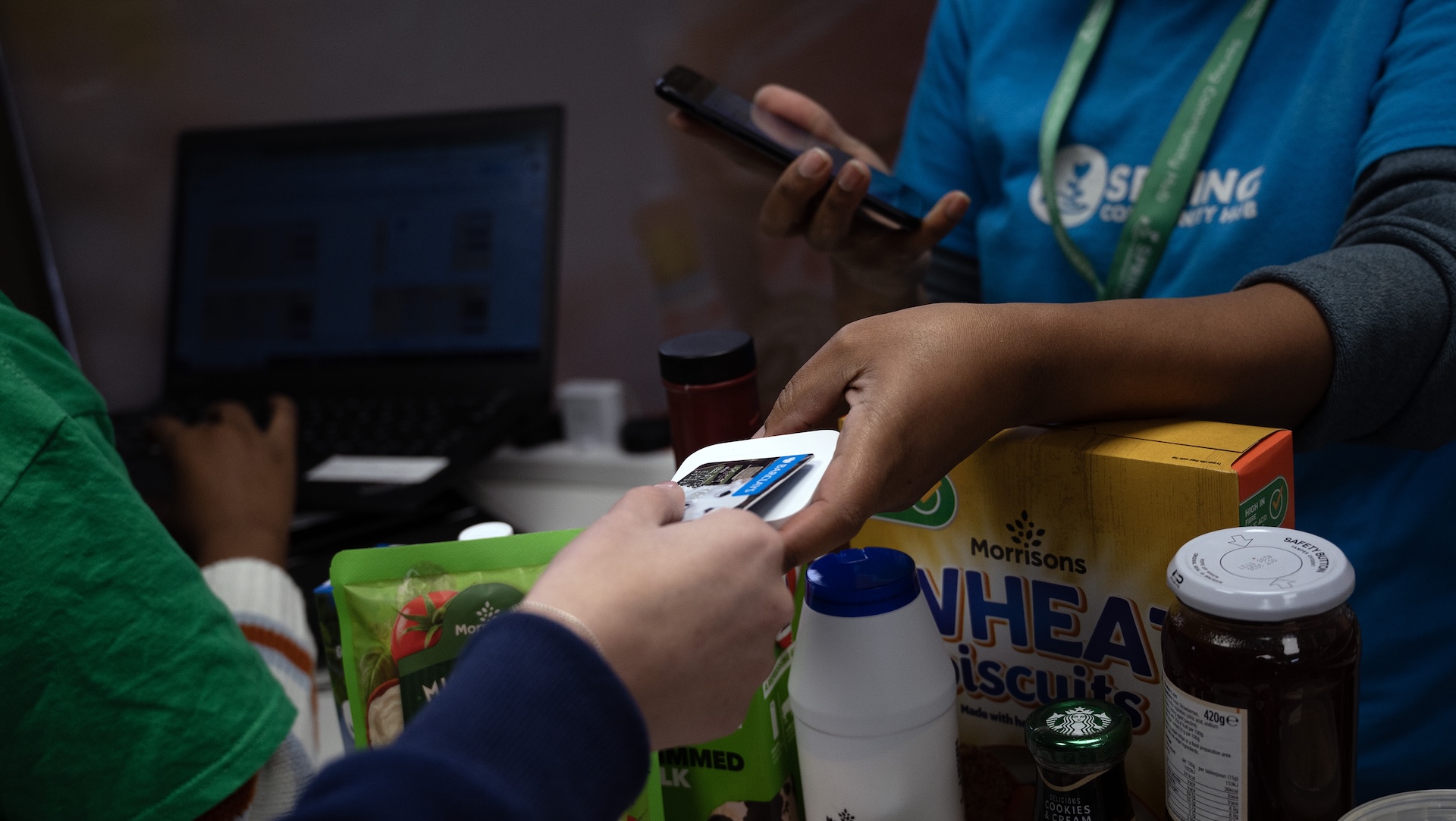 A person buying products at a social supermarket at the Spring Community Hub.